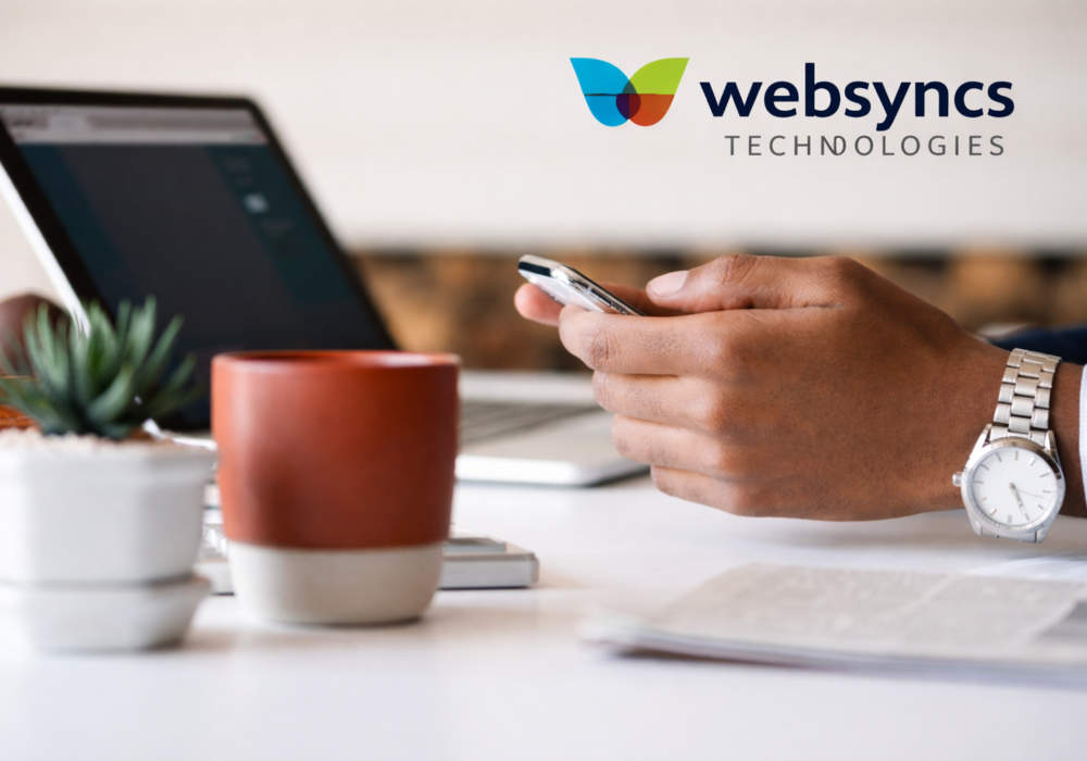 Professional mobile app development workspace with smartphone, laptop, and Websyncs Technologies logo